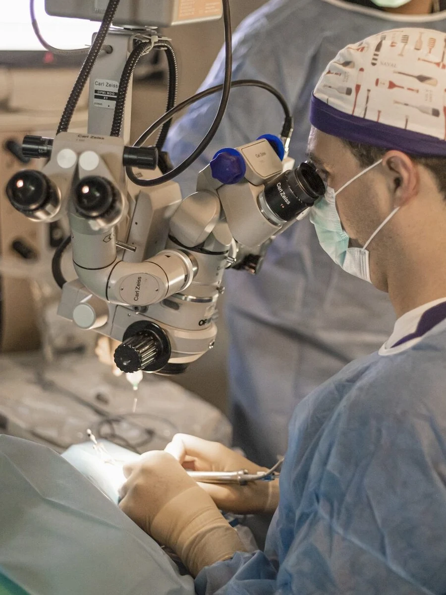 Dr. Batlle Logroño operando con microscopio quirúrgico